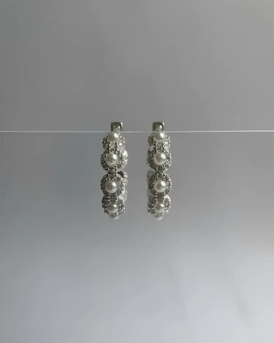 Aros circulares de plata 925 con diseño de flores perladas, elegancia atemporal de Sylara.