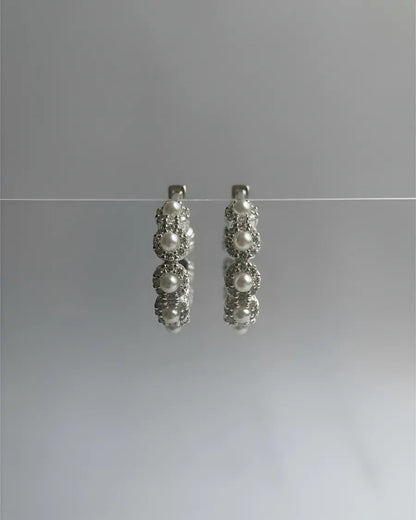 Aros circulares de plata 925 con diseño de flores perladas, elegancia atemporal de Sylara.