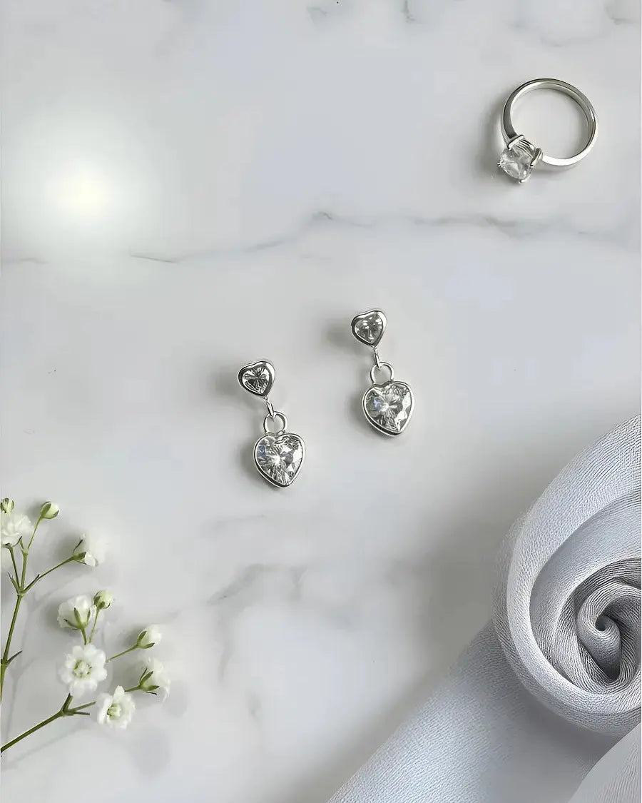 Aros corazón colgante blanco de plata 925 vistos de lado, joya moderna Sylara.