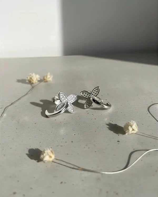 Modelo usando aros flor plata circular, joya brillante y femenina de Sylara.