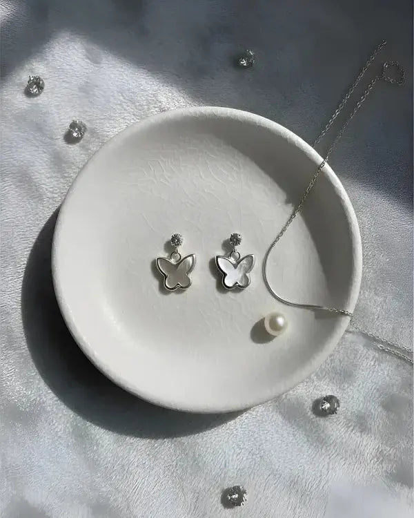 Aros colgantes mariposa blanca, brillo delicado en plata 925 de Sylara.